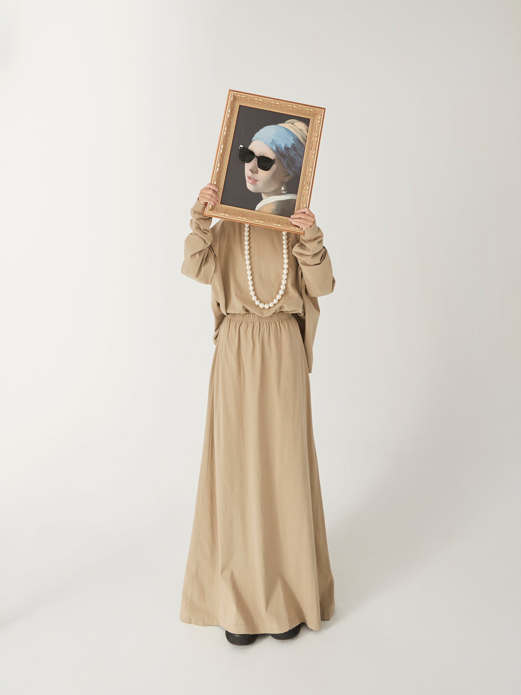 DAMNARTS Girl with a Pearl Earring glasses holder worn in a lifestyle photo against a white background, featuring black sunglasses on the artwork.