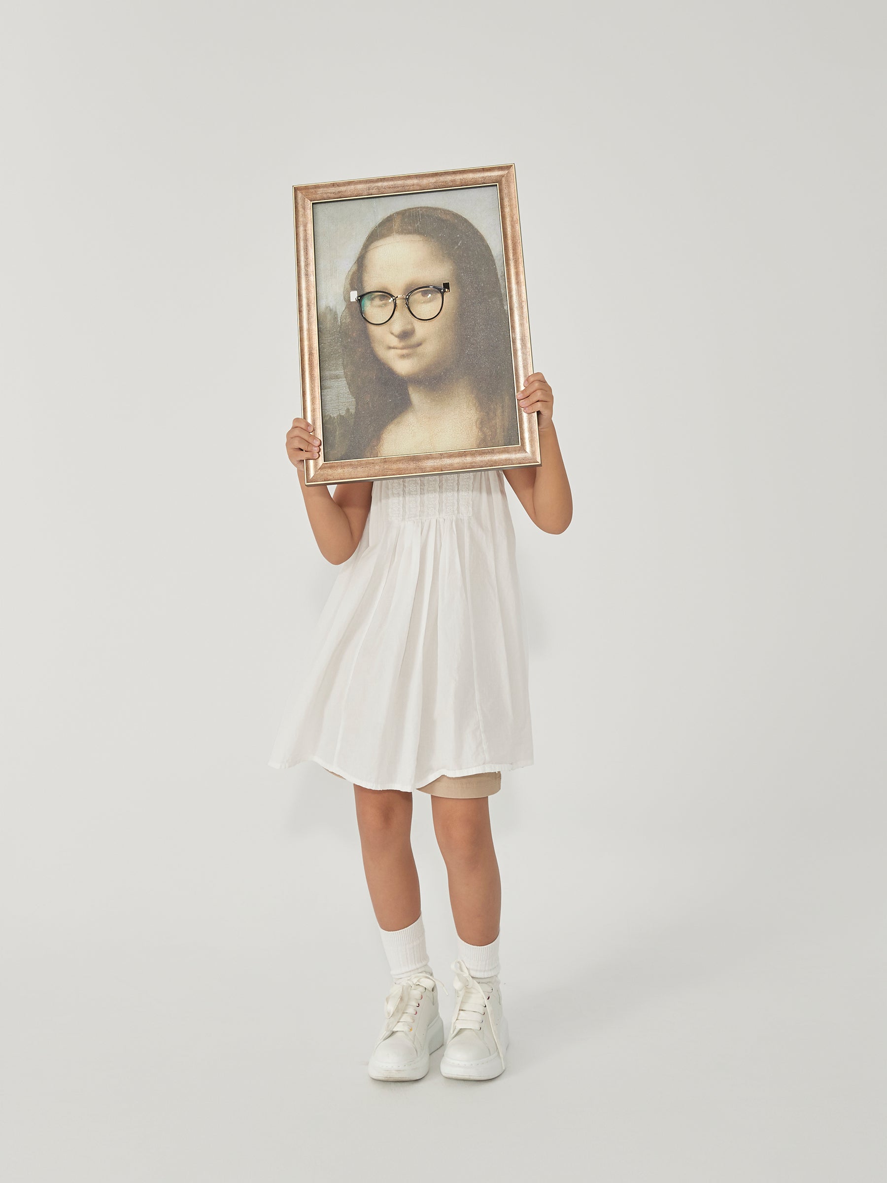 DAMNARTS Mona Lisa glasses holder lifestyle photo on white background, model holding the artwork with round optical glasses.