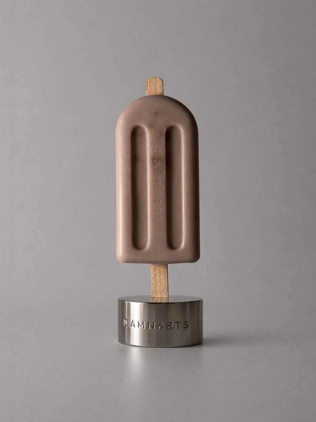 DAMNARTS Desert Sand scented ice pop candle on metal base, minimalist product shot