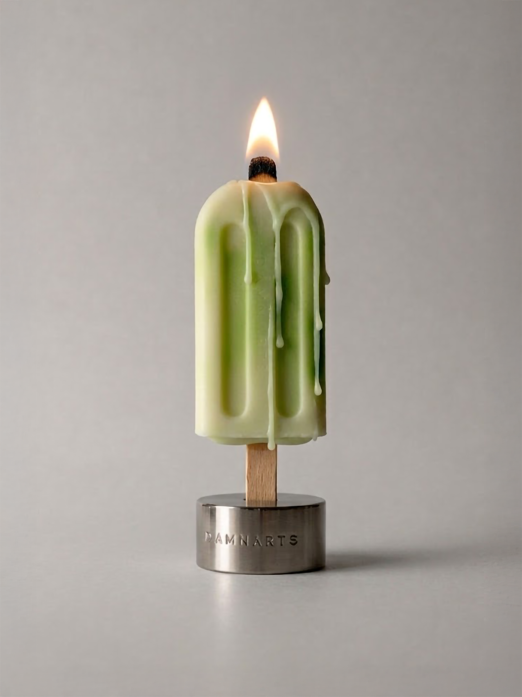 DAMNARTS Forest Mist scented ice pop candle burning with melting wax dripping