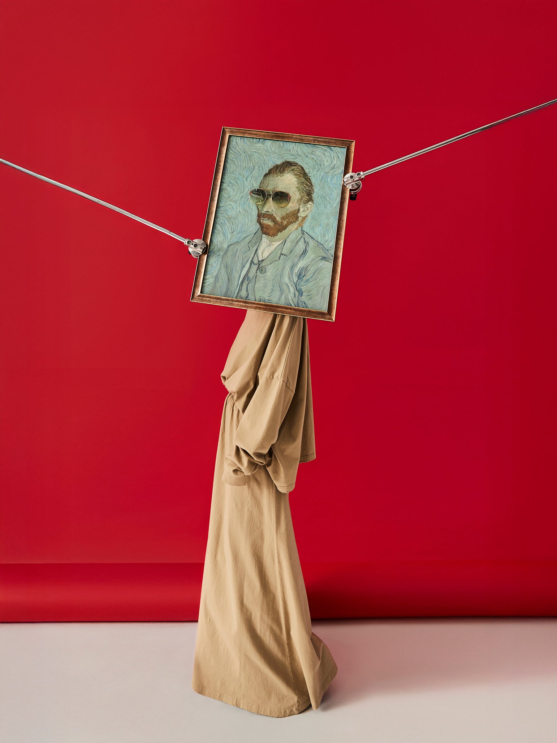 DAMNARTS Vincent van Gogh glasses holder photographed against a red background, featuring sunglasses on the framed artwork as a wearable display.